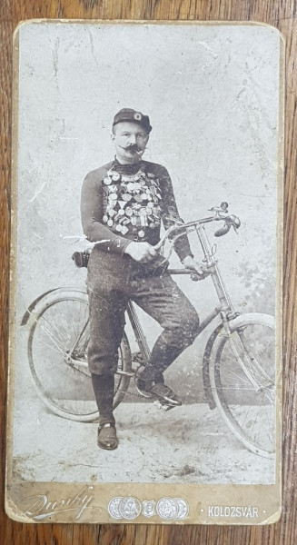 CICLIST CU MEDALII SI DECORATII , PE BICICLETA SA , POZAND IN STUDIO , FOTOGRAFIE TIP CABINET , STUDIO DUNKY , CLUJ , CCA, 1900, PREZINTA URME DE UZURA *